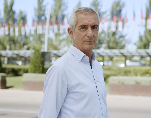 Rewind Ambassador Santiago Quiroga walking in front of a short hedge wall with trees in the background